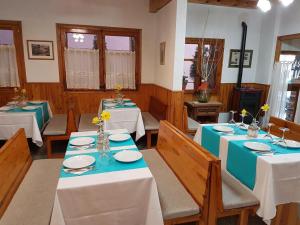 un comedor con mesas y sillas con manteles azules y blancos en Hostal Casa Palmira, en Espot