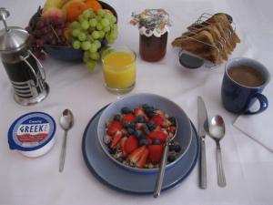 a table with a bowl of fruit and a bowl of juice at Perfect for Petersfield B&B in Petersfield