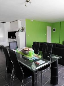 a living room with a table with chairs and green walls at Apartment at Gagijevo sedlo in Morović