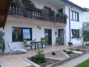 a patio with chairs and a table in front of a house at Gästehaus Natterer - FeWo 1 in Momlingen