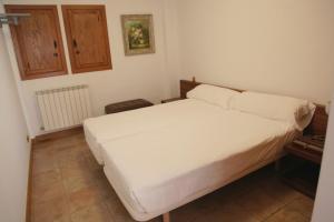 1 dormitorio con 1 cama blanca en una habitación en Apartamento Sarzaleta, en Galdeano