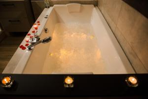 a bath tub filled with water with candles in it at La Suite Romantique avec Jacuzzi au Cœur de Perpignan in Perpignan