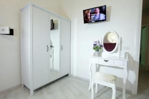 un bagno bianco con specchio e toletta di Appartamenti Romatour a Roma