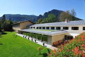a building with a large yard with flowers at BSW Hotel Hubertus-Park in Schönau am Königssee