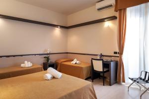 a hotel room with two beds and a table at Hotel Mondial in Porto Recanati