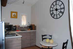 une cuisine avec une table et une horloge murale dans l'établissement Tybolea, à Cavaillon