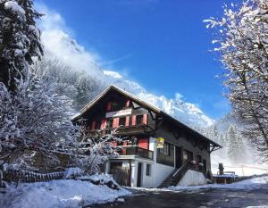 um edifício coberto de neve com uma montanha coberta de neve em Guest House du Grand Paradis - On Piste em Champéry