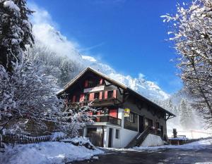 a snow covered building with a snow covered mountain at Guest House du Grand Paradis - On Piste in Champéry