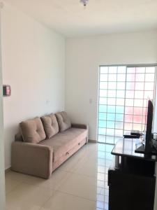 a living room with a couch and a television at Casa do Disco Voador in São Thomé das Letras