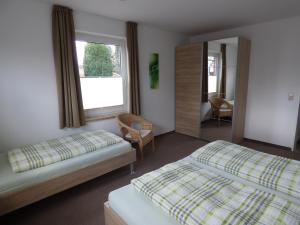 Habitación de hotel con 2 camas y espejo en Ferienhaus Tamm-Voß en Grömitz