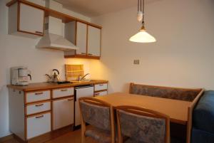 a kitchen with a table and chairs and a kitchen with a sink at Matailerhof in Tirolo