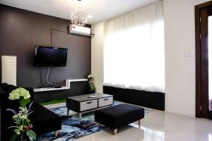 a living room with a couch and a tv at Sibu Swanhouse No.3 in Sibu