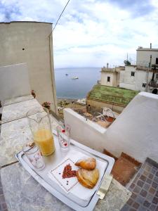 a tray with a plate of food and a glass of orange juice at Nonna Enza Apartment in Atrani