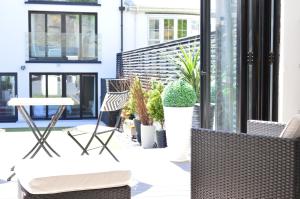 a patio with chairs and a table and plants at Pier39Portrush Adult Only in Portrush