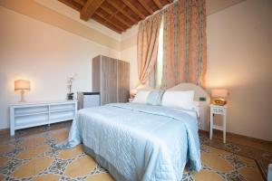 a bedroom with a bed with a blue comforter at Lucca Relais in Lucca