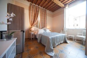 Lucca Relais في لوكّا: غرفة نوم بسرير ونافذة كبيرة
