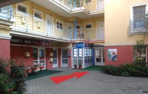 a building with two red arrows in front of it at Apartman Vera in Hévíz