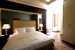 une chambre avec un grand lit avec un grand miroir dans l'établissement Nehal Hotel, à Abu Dhabi