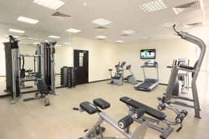 une salle de sport avec plusieurs tapis de course et machines cardio dans l'établissement Nehal Hotel, à Abu Dhabi