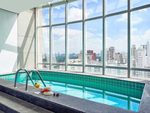 a swimming pool with a view of a city at Flat Parque Ibirapuera in São Paulo