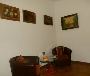 un soggiorno con 2 sedie e un tavolo di 4 Rooms Piata Sfatului a Braşov