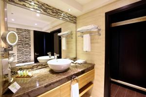 une salle de bain avec deux lavabos et un grand miroir dans l'établissement Nehal Hotel, à Abu Dhabi