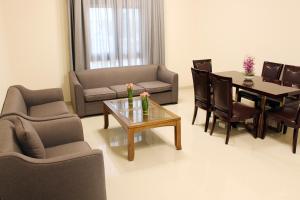sala de estar con sofá, mesa y sillas en Al Noor Plaza, en Salalah