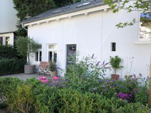 a white house with flowers in front of it at Das ELBCOTTAGE in Hamburg