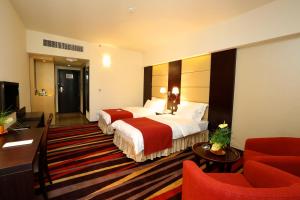 a hotel room with two beds and a television at Nehal Hotel in Abu Dhabi