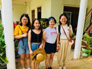 a group of four girls standing next to a building at Sudu Neluma Home Stay in Polonnaruwa