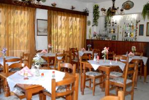 une salle à manger avec des tables et des chaises en bois dans l'établissement Anthula Sun, à Archangelos