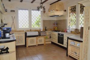 a large kitchen with white cabinets and a stove at Casa del artista in Arona