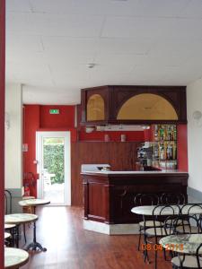 un restaurant avec un bar doté de tables et de chaises dans l'établissement Hôtel Hélios, à Lourdes