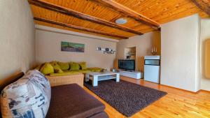 een woonkamer met een bank en een tv bij Apartment Anna in Kežmarok