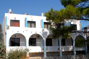 a white building with trees in front of it at Anthula Sun in Archangelos