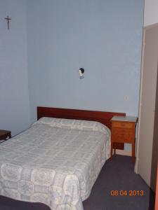 Giường trong phòng chung tại Hôtel Hélios