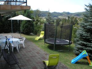 un cortile con tappeto elastico, tavolo e sedie di Apartments Country House Stipica a Tuheljske Toplice