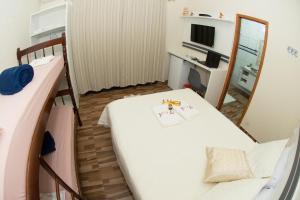 a small room with a bed and a mirror at Pousada Fiedler E Anacleto in Penha
