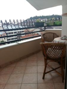 a balcony with a table and a chair and a window at T&A Apartments in Ohrid