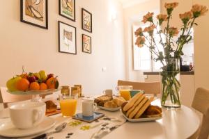 a table with a plate of food and orange juice at casa minù lamarmora in Cagliari