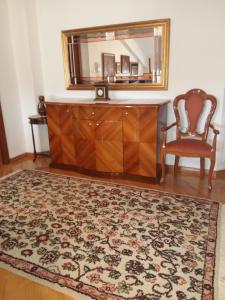 a dresser with a mirror and a chair in a room at T&A Apartments in Ohrid