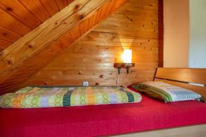 a bed in a room with a wooden wall at Boskovica Brvnare in Žabljak