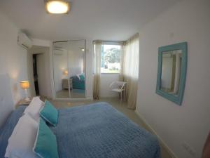 プンタ・デル・エステにあるWind Towerのベッドルーム(青いベッド1台、鏡付)