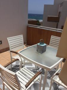 una mesa y sillas en un balcón con vistas en atico coqueto los martines en El Médano