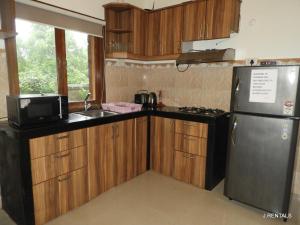 アンジュナにあるAnjuna Villa 32のキッチン(木製キャビネット、ステンレス製の冷蔵庫付)