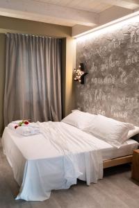 ein Schlafzimmer mit einem weißen Bett und einer Wand mit einem Schreibtisch in der Unterkunft B&B Dei Poeti in Civitanova Marche