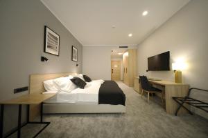 a bedroom with a bed and a desk and a television at Teatro Verdi Boutique Hotel in Zadar