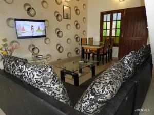 a living room with a black and white couch and a table at Anjuna Villa 32 in Anjuna