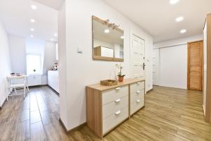 a bathroom with a dresser and a mirror at Apartament Centrum in Toruń