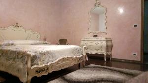a bedroom with a white bed and a mirror at Villa Berra - Via Postale 63/A in Berra